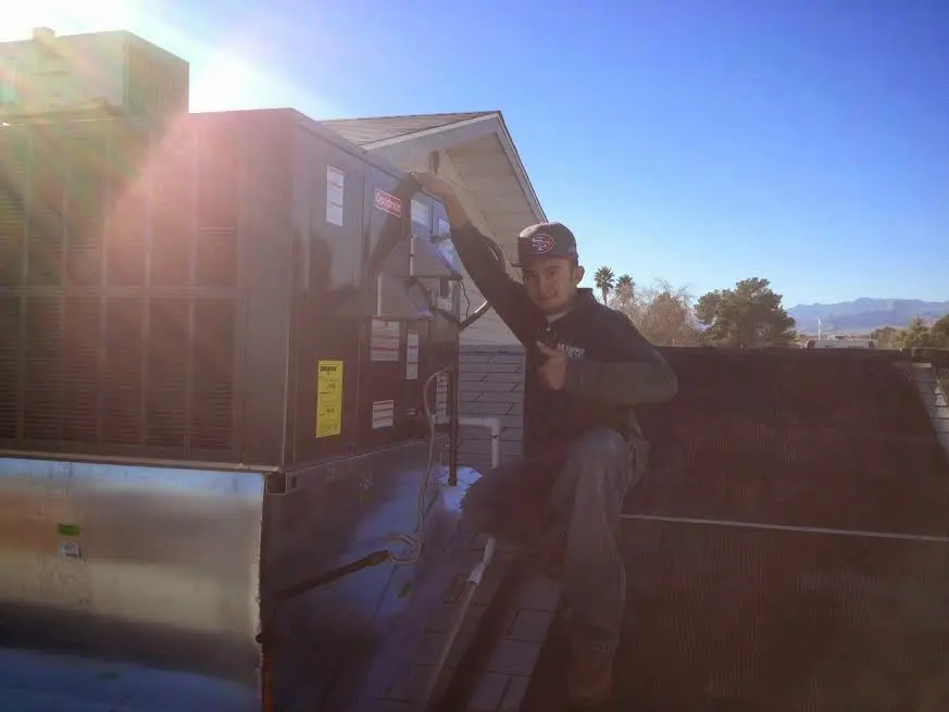 HVAC technician performing Air Duct Cleaning on a rooftop unit in Lake Charles